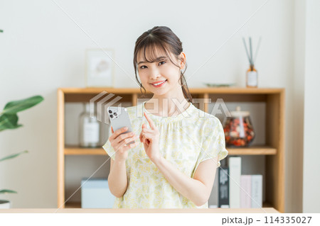 リビングでスマホを操作する女性。 リビングでスマホを操作する女性。 114335027
