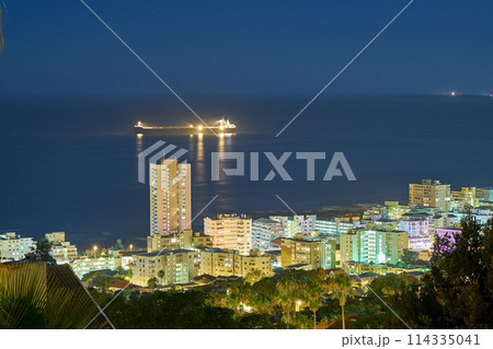 City, skyline and night with sea, landscape and ocean for holiday location or outdoor journey. Miami, sunshine and infrastructure for road trip, travel or urban cityscape for scenic view for tourism 114335041