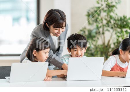 プログラム学習をする小学生と講師。 114335552