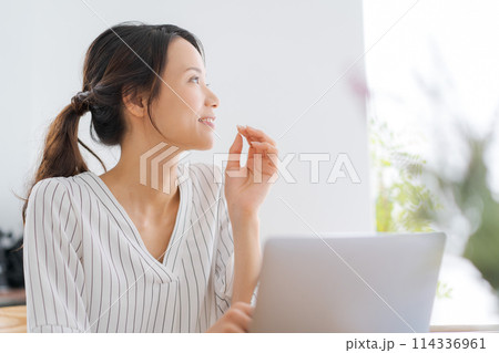 パソコンの前で考え事をする女性 パソコンの前で考え事をする女性 114336961