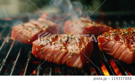 Tuna steaks with sesame seeds grilled over open flame. 114337888