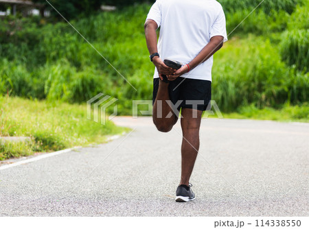 Close up Asian young athlete sport runner black man wear watch lift feet stretching legs and knee before running at the outdoor street health park, healthy exercise before workout concept Close up Asian young athlete sport runner black man wear watch lift feet stretching legs and knee before running at the outdoor street health park, healthy exercise before workout concept 114338550