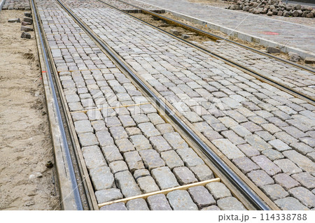 Newly replaced tram tracks and intermediate track surface, historic cube-shaped granite cobblestones 114338788
