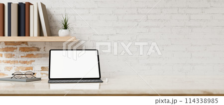 A white-screen digital tablet mockup on a table against the white rustic brick wall. A white-screen digital tablet mockup on a table against the white rustic brick wall. 114338985