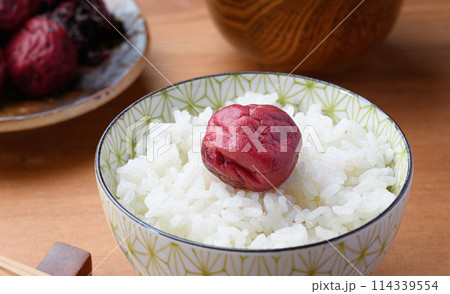 ご飯にのせた昔ながらの酸っぱい梅干し ご飯にのせた昔ながらの酸っぱい梅干し 114339554