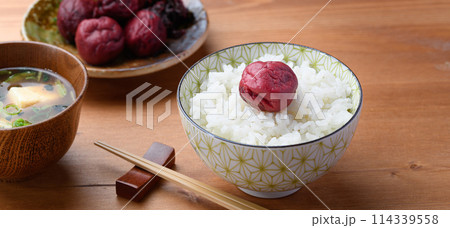 ご飯にのせた昔ながらの酸っぱい梅干し ご飯にのせた昔ながらの酸っぱい梅干し 114339558