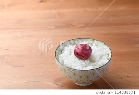 ご飯にのせた昔ながらの酸っぱい梅干し ご飯にのせた昔ながらの酸っぱい梅干し 114339571