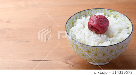 ご飯にのせた昔ながらの酸っぱい梅干し ご飯にのせた昔ながらの酸っぱい梅干し 114339572