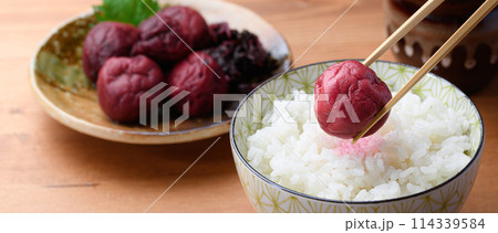ご飯にのせた昔ながらの酸っぱい梅干し ご飯にのせた昔ながらの酸っぱい梅干し 114339584