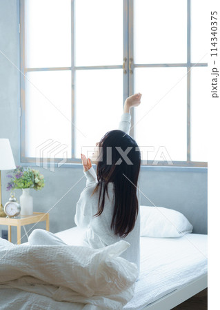 目覚めの良い朝を迎えた若い女性 目覚めの良い朝を迎えた若い女性 114340375