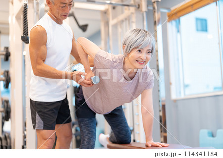 ジムで筋トレをするシニア夫婦 ジムで筋トレをするシニア夫婦 114341184