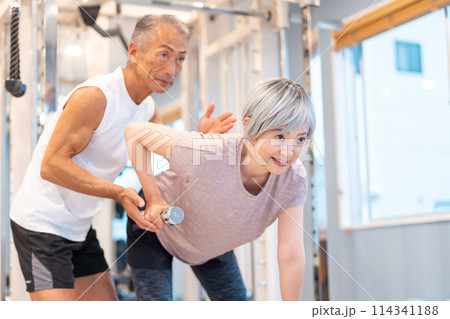 ジムで筋トレをするシニア夫婦 114341188