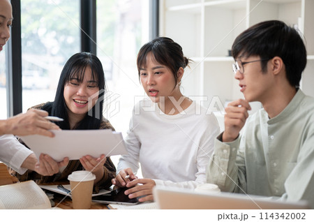 A group of Asian university students is studying math with a senior professor in the classroom. A group of Asian university students is studying math with a senior professor in the classroom. 114342002
