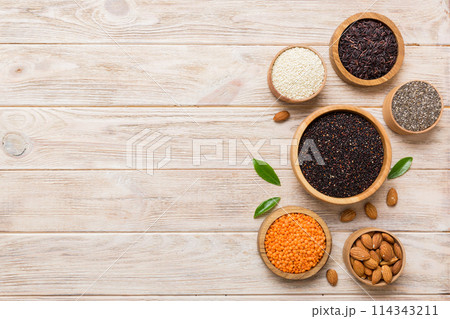 Various superfoods in smal bowl on colored background. Superfood as rice, chia, quinoa, lentils, nuts, sesame seeds, almonds. top view copy space Various superfoods in smal bowl on colored background. Superfood as rice, chia, quinoa, lentils, nuts, sesame seeds, almonds. top view copy space 114343211