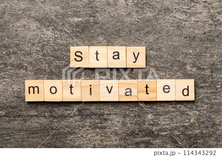 Stay motivated word written on wood block. Stay motivated text on cement table for your desing, concept Stay motivated word written on wood block. Stay motivated text on cement table for your desing, concept 114343292