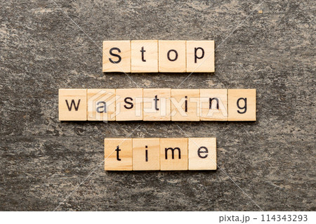 Stop wasting time word written on wood block. Stop wasting time text on cement table for your desing, Top view concept Stop wasting time word written on wood block. Stop wasting time text on cement table for your desing, Top view concept 114343293