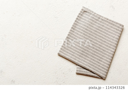 top view with gray kitchen napkin isolated on table background. Folded cloth for mockup with copy space, Flat lay. Minimal style top view with gray kitchen napkin isolated on table background. Folded cloth for mockup with copy space, Flat lay. Minimal style 114343326