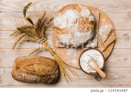 Freshly baked bread on cutting board against white wooden background. top view bread with copy space 114343497