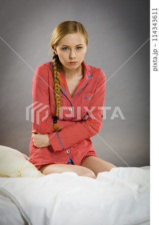 Sad young teenager woman sitting on bed 114343611