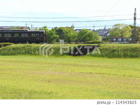 世界遺産の平城宮跡内の復元遺跡横を走行する近鉄電車 世界遺産の平城宮跡内の復元遺跡横を走行する近鉄電車 114343825