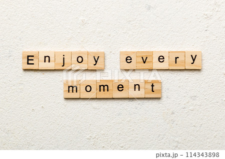 Enjoy Every Moment word written on wood block. Enjoy Every Moment text on cement table for your desing, concept 114343898