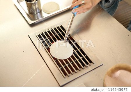 草加せんべい手焼き体験をする女性 114343975