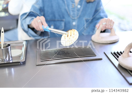 草加せんべい手焼き体験をする女性 114343982