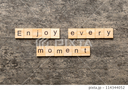 Enjoy Every Moment word written on wood block. Enjoy Every Moment text on cement table for your desing, concept Enjoy Every Moment word written on wood block. Enjoy Every Moment text on cement table for your desing, concept 114344052