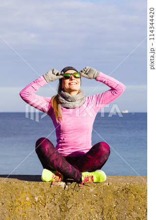 Woman resting after doing sports outdoors on cold day 114344420