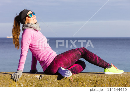 Woman resting after doing sports outdoors on cold day 114344430