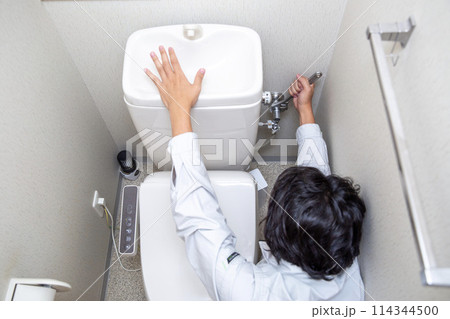 トイレの修理をする業者の男性 トイレの修理をする業者の男性 114344500
