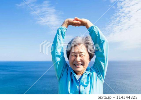 海を背景に背伸びする女性 114344825