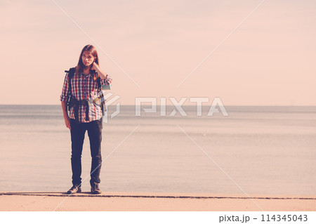 Man hiker with backpack tramping by seaside 114345043