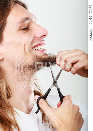 Man cutting his beard Man cutting his beard 114345173