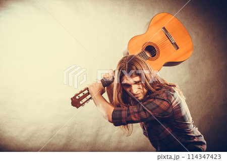 Rock musician destroys his guitar. 114347423