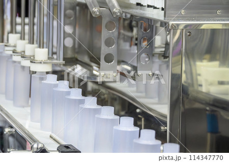 The empty healthcare bottles on the conveyor belt for filling process. T The empty healthcare bottles on the conveyor belt for filling process. T 114347770