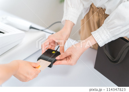 服屋・雑貨屋でクレジットカードを使ってキャッシュレス決済する女性 114347823
