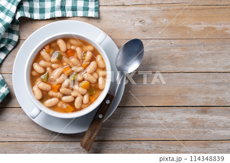 White beans soup with vegetables in white bowl on wooden table White beans soup with vegetables in white bowl on wooden table 114348839