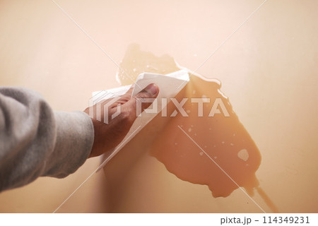 hand wiping spilled tea with paper napkin on floor , 114349231
