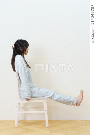 椅子に座って運動をする若い女性 椅子に座って運動をする若い女性 114349787