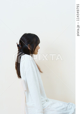 椅子に座って運動をする若い女性 椅子に座って運動をする若い女性 114349791