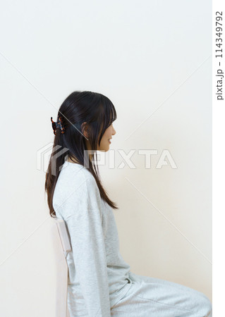 椅子に座って運動をする若い女性 椅子に座って運動をする若い女性 114349792