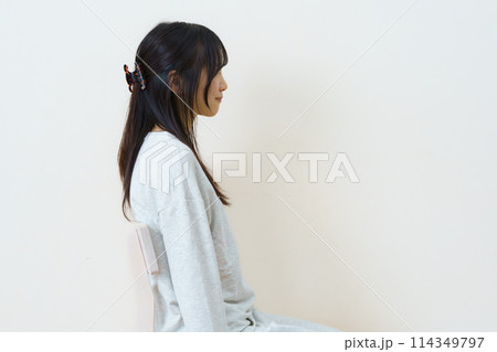 椅子に座って運動をする若い女性 114349797