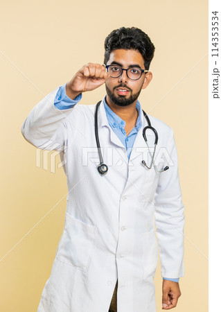Excited Indian doctor man knocking door gesture asking who is at home, feeling embarrassed, no idea 114353534