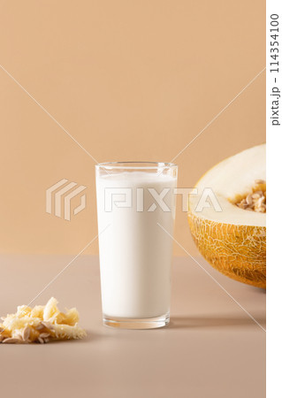 Alternative melon seeds milk and seeds on beige background. Close up. Vertical format. Healthy food concept. Vegan fruit based milk. 114354100