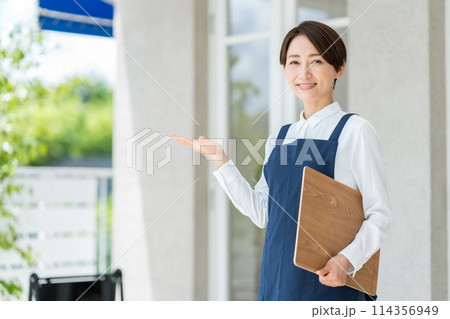 カフェの店内に案内する女性 114356949