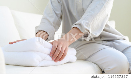 タオルをたたむ女性 114357837