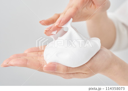 細かい泡のかたまりを手のひらに乗せる女性の手 114358073
