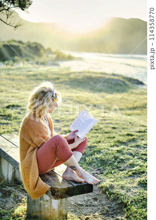 Young mature blonde woman reading outdoor. Young mature blonde woman reading outdoor. 114358770
