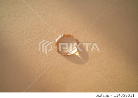 Beautiful volumetric drop of cosmetic product on a beige background. Beautiful volumetric drop of cosmetic product on a beige background. 114359011